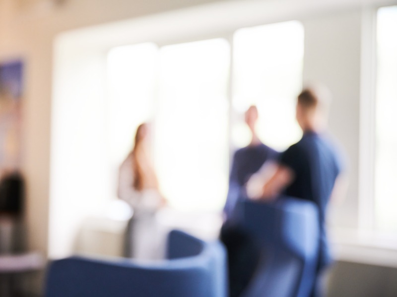 Employees discussing in front of a window